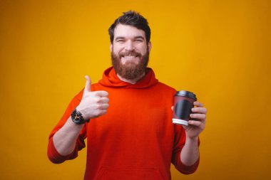 Sakallı adam elinde yemek kupası tutuyor. Kahveni internetten sipariş et ve evde kal..