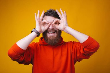 Sarı arka plandaki genç sakallı adam heyecanlı....