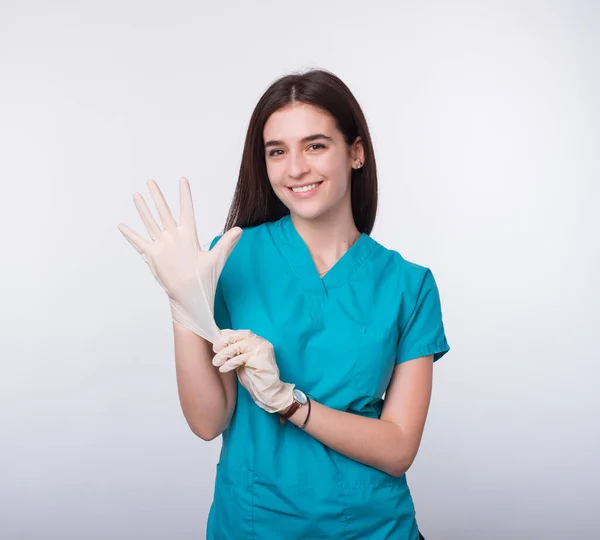 Sorridente medico femminile dice non dimenticate di indossare guanti monouso per la vostra protezione . — Foto Stock
