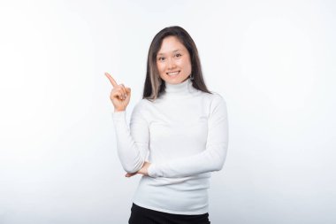 Beyazlar içindeki gülümseyen kız açık bir arkaplanı işaret ediyor..