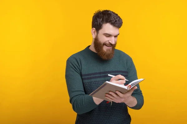 Schöner junger Mann schreibt in Agenda, verwalte deine Zeit — Stockfoto