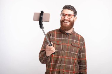 Gülümseyen adam beyaz arka planda özçekim yapıyor..