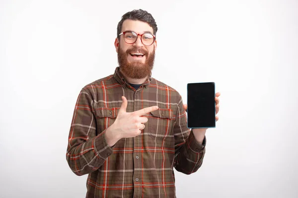 Estudiante masculino está apuntando a una pantalla en blanco de una tableta sobre fondo blanco . — Foto de Stock