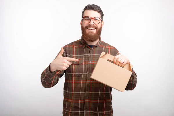Gülümseyen sakallı adam elinde tuttuğu teslimat kutusunu işaret ediyor.. — Stok fotoğraf