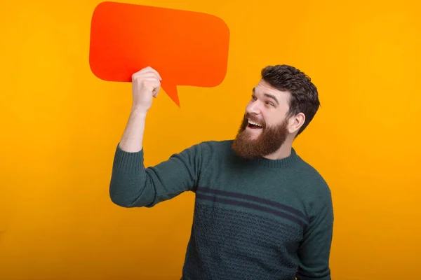 Aufgeregter Mann blickt auf die Blasenrede, die er hält. — Stockfoto