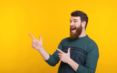 Heyecanlı adam iki elini de sarı arka planda gösteriyor..
