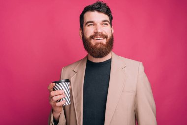 Hayalci adam, elinde pembe bir fincanla çok uzaklara bakıyor..