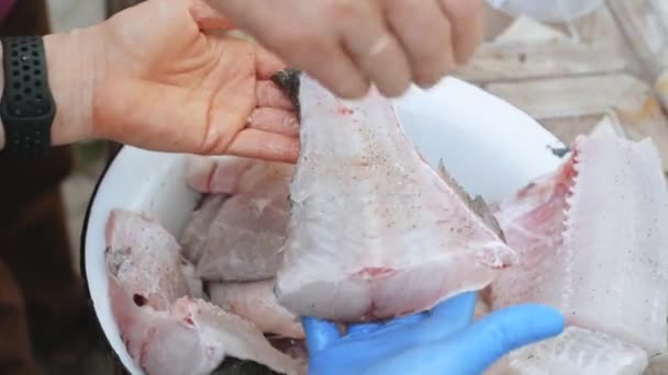 Záběry, ženy ruce příprava ryb pro vaření v misce — Stock video