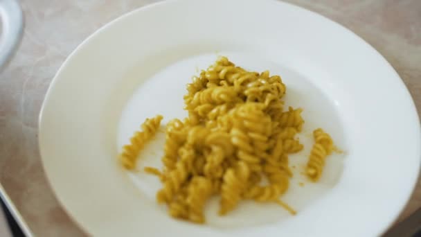 Шеф-кухар кладе макарони в білу тарілку на кухню, готуючи їжу — стокове відео