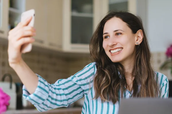 Sonriente joven mujer haciendo selfie o filmando vlog desde smartphon — Foto de Stock