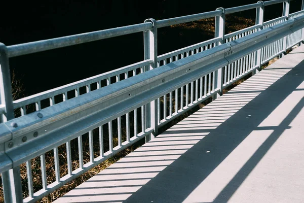 Disegno astratto delle ombre della ringhiera del ponte sul marciapiede sul ponte — Foto Stock