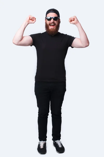 Фотографія на повну довжину вражена бородатим чоловіком, який святкує перемогу над білим — стокове фото