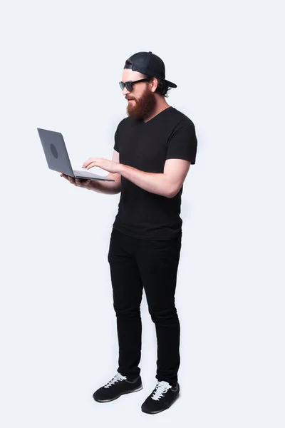 Teljes hosszúságú fotó szakállas férfiról a laptopjával — Stock Fotó