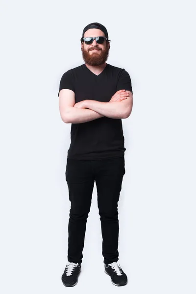 Portrait of bearded man looking confident at the camera standing with crossed arms — Stock Photo, Image