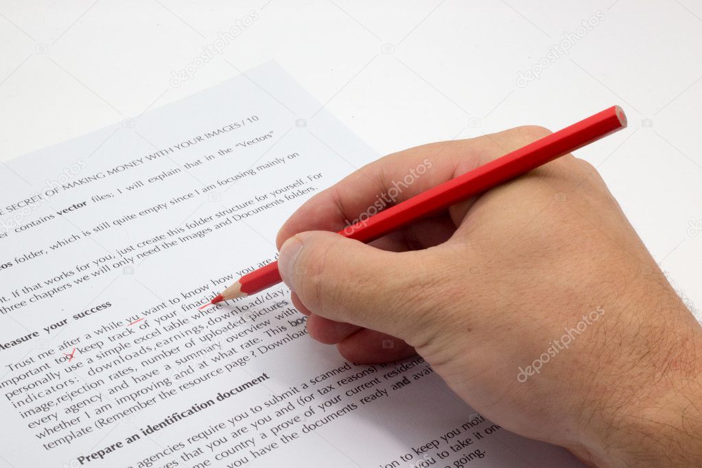 Hand doing proofreading on a faulty text with red pen Stock Photo