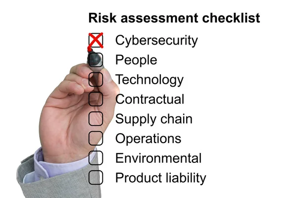 Hånden krysser av det første elementet i en sjekkliste for risikovurdering – stockfoto