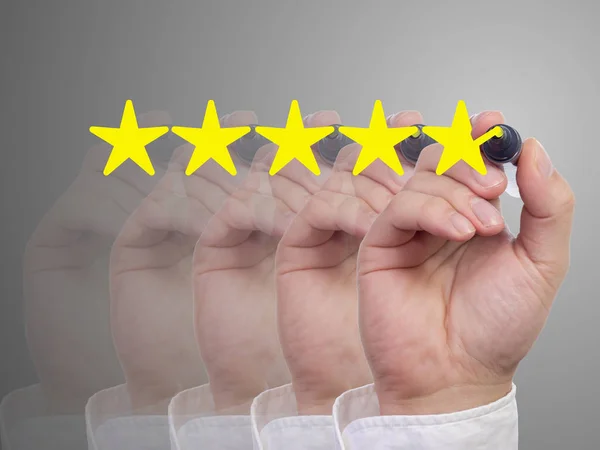 Five fading hands with a pen giving a five star review — Stock Photo, Image