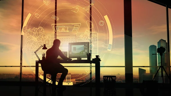 At sunset, a photographer in his office in front of a holographic projection. — Stock Photo, Image