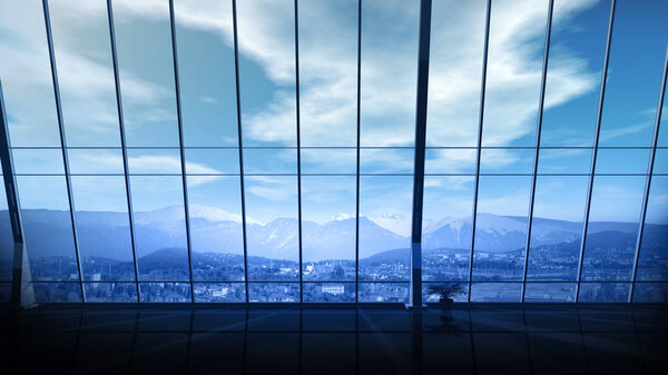 Empty office space with panoramic window overlooking the snow-capped peaks of the mountains.