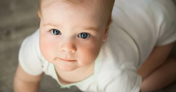 Bebek duygular. Beyaz t shirt mavi gözlü kız bebek bakmak cam içinde. Yeni doğan. Yakın çekim.