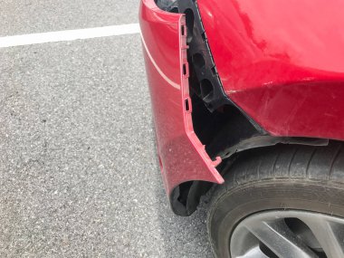 Kırmızı araba kazasının ön tamponu kırılmış.