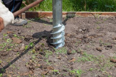 Güneşli bir günde yerde işçi manuel sondaj deliği