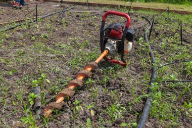 Güneşli bir günde yerde elle delme makinesi var.