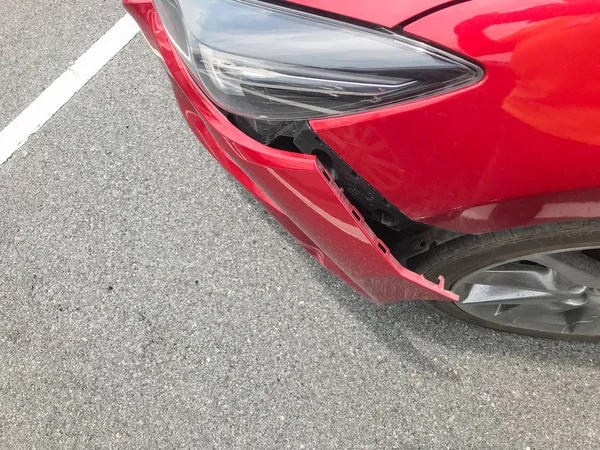 Broken front bumper of red car crash — Stock Photo, Image