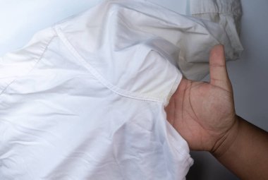 Beyaz koltukaltı tişörtünde sarı kirli ter lekesi
