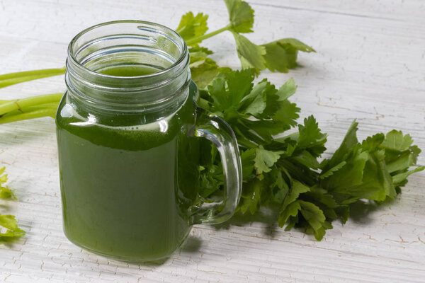 close up of fresh green celery juice on glass