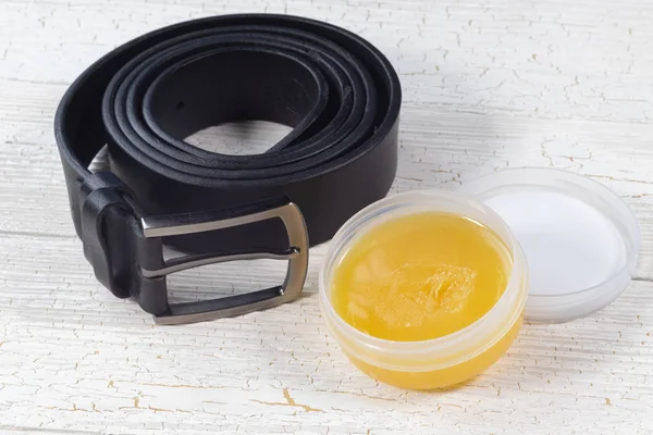 Cinturón de cuero negro y aceite de visón para el cuidado de productos de cuero —  Fotos de Stock