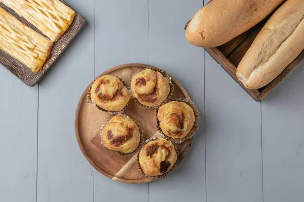 Disposición plana de variedad de panadería y cerdo rallado danés en tablero de madera — Foto de Stock