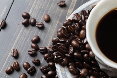 Bir fincan sıcak kahve ve kahve çekirdeği.