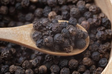 Kara biber ve ahşap kaşık yığınını kapat.