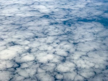 Bulutlar ve gökyüzü bir uçağın penceresinden görüldüğü gibi