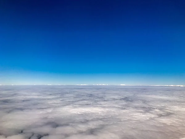 Wolken und Himmel aus dem Fenster eines Flugzeugs — Stockfoto