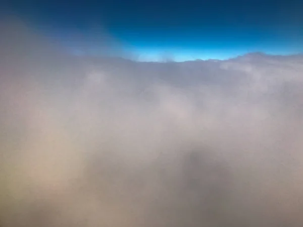 Nuvens e céu como visto através da janela de uma aeronave — Fotografia de Stock