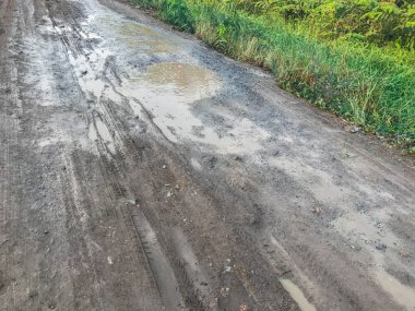 Delik ve kötü kırık yolda su birikintileri