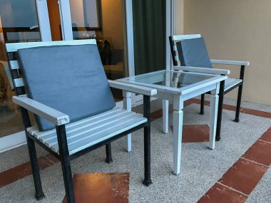 Deniz kenarında ahşap masaları ve sandalyeleri olan bir kafe.