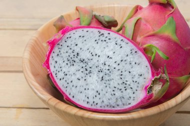 close up of dragon fruit on wooden bowl