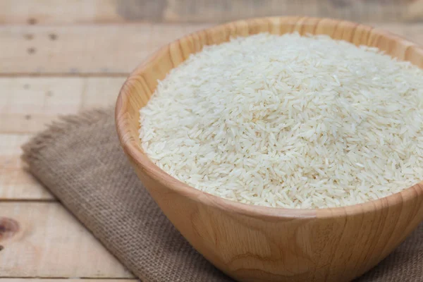 Close up de arroz branco cru em tigela de madeira — Fotografia de Stock