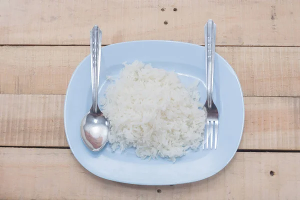 Arroz cozido em prato, arroz cozido com colher e garfo — Fotografia de Stock