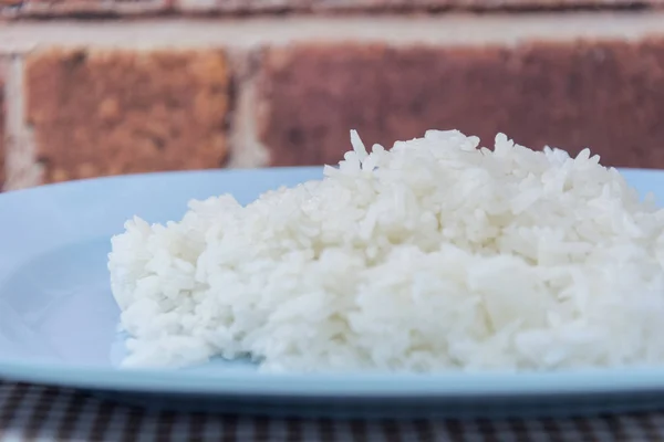 Arroz cozido em prato, arroz cozido com colher e garfo — Fotografia de Stock