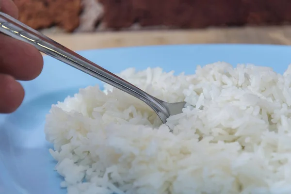 Arroz cozido em prato, gelo cozido com colher e garfo — Fotografia de Stock