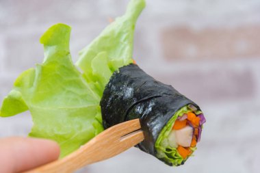 close up of vegetable salad roll and sauce