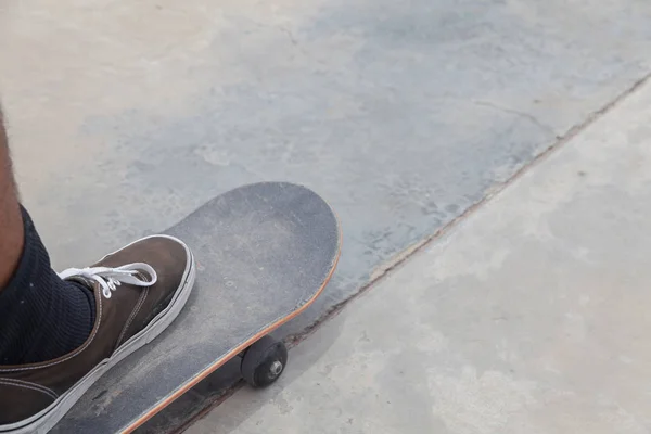 Chaussure de plein air et planche à roulettes sur rampe en béton — Photo
