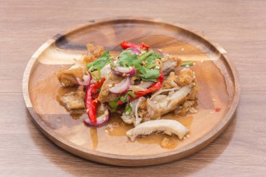 Spicy fried Chicken Salad on wooden plate