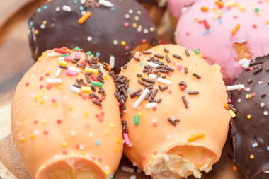 Tahta tabakta çeşitli çörekler serpiştirilmiş.