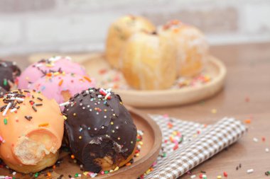 Tahta tabakta çeşitli çörekler serpiştirilmiş.