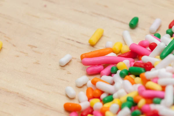 Close up bunte Regenbogen Streusel auf Holzteller — Stockfoto